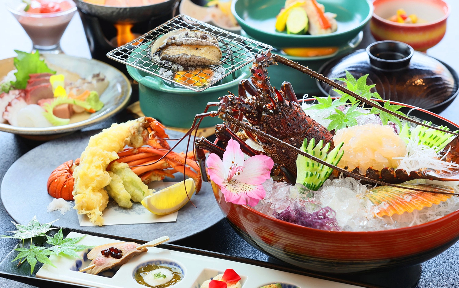 伊勢海老の刺身や天ぷら、鮑の踊り焼きなど豪華な和食料理が食卓に並んでいます。