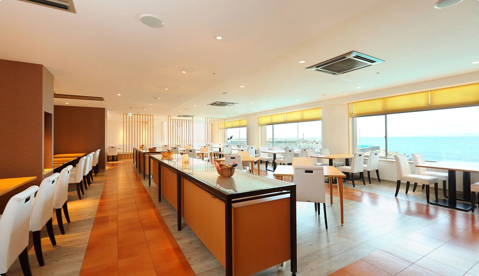 海が見える窓際席が並ぶ、清潔感のある明るい店内の様子です。