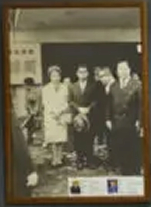 室内で正装した男女数人が一列に並んで記念撮影をしています。