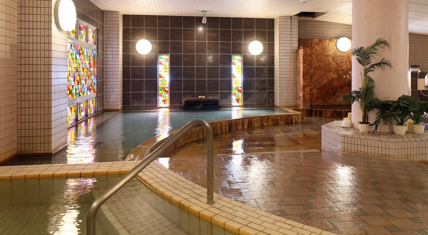 色鮮やかなステンドグラスが飾られた、落ち着いた雰囲気の屋内大浴場です。