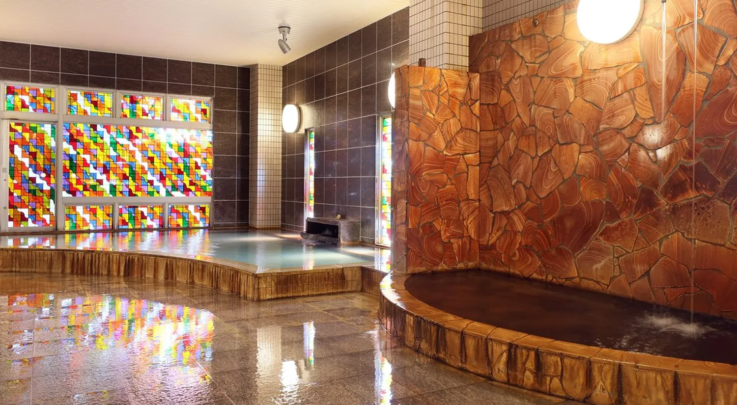 色鮮やかなステンドグラスが壁面を彩る、落ち着いた雰囲気の温泉浴場があります。