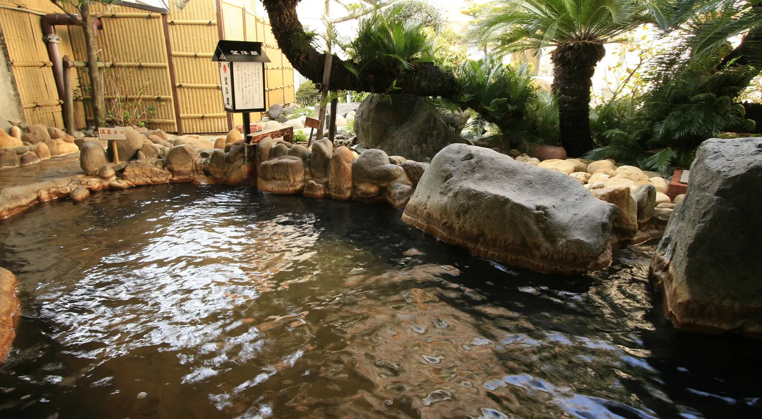 竹垣に囲まれ、大きな岩や木々が配された静かな露天風呂があります。