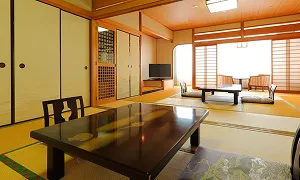 障子や畳が広がる和室に、木製のテーブルや椅子が整然と配置されています。