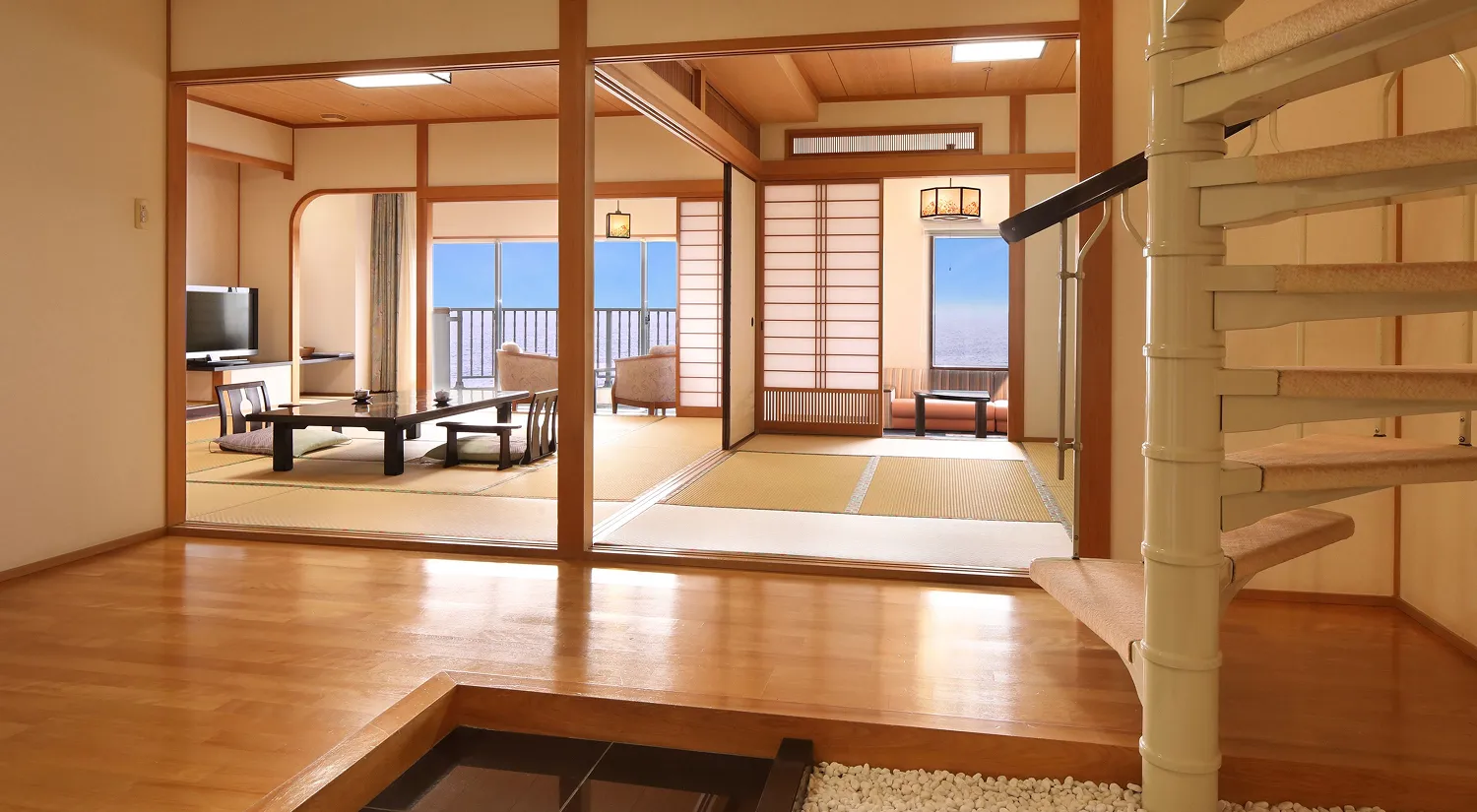 海が見える和室が広がり、手前には螺旋階段が設置されています。