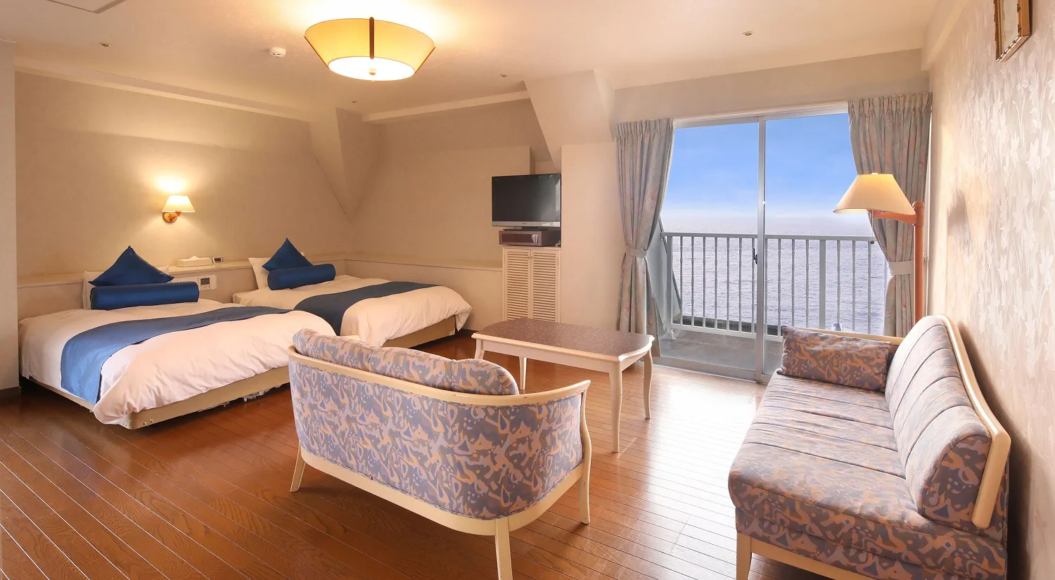 海が見えるバルコニー付きの客室には、二つのベッドとソファが並んでいます。