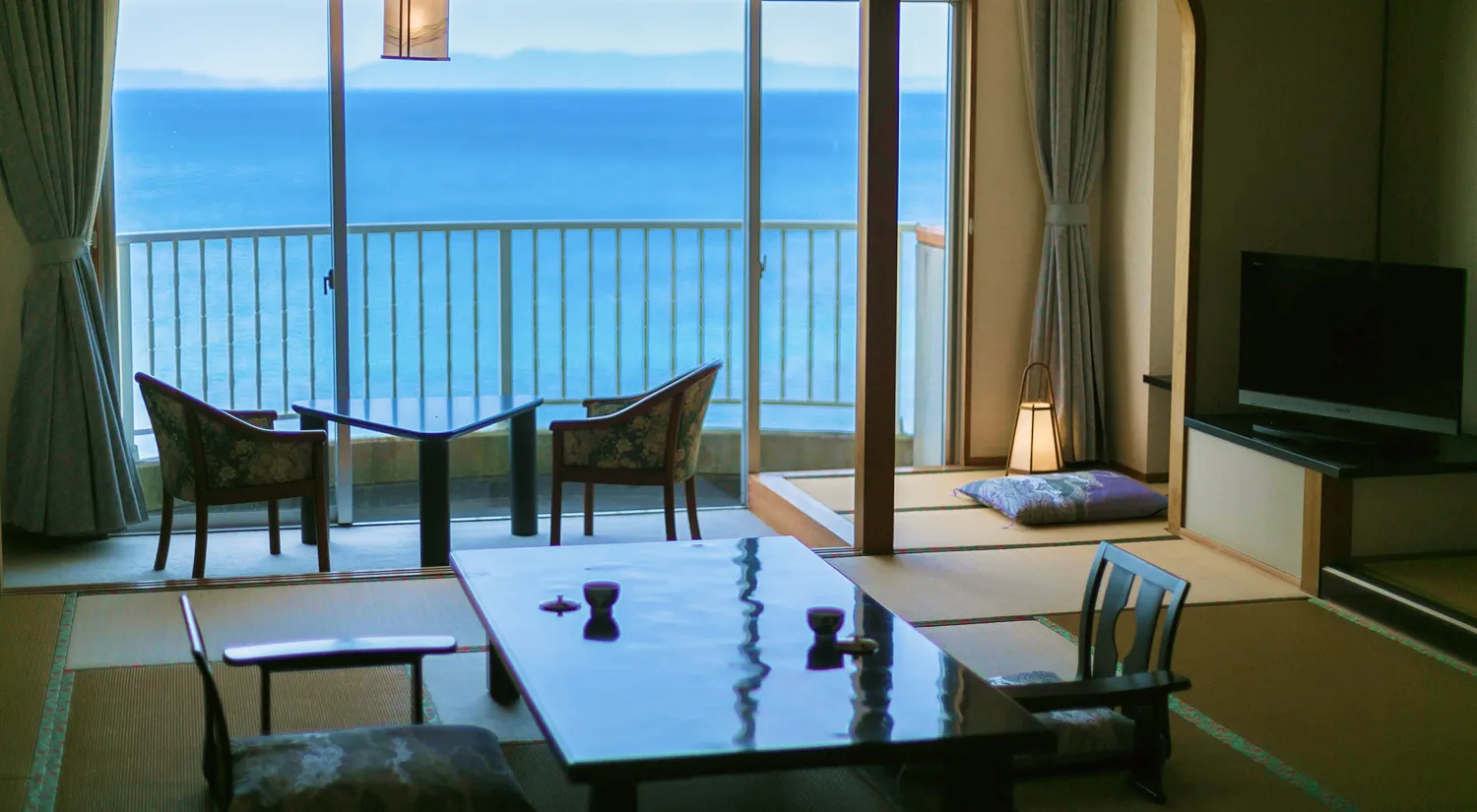 和室から青い海が一望できる、落ち着いた雰囲気の客室が広がっています。